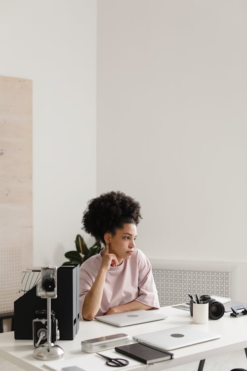 Pensive Woman sitting beside a Table 