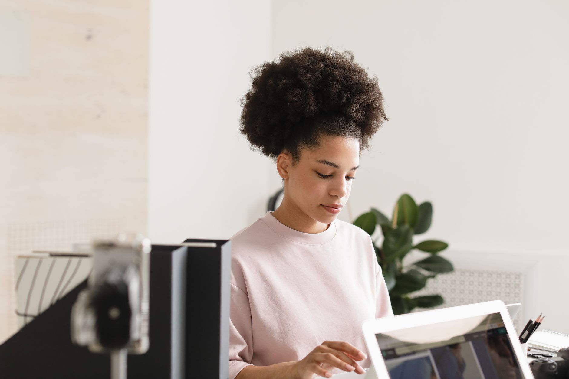 African American woman working on a computer in a modern office setting.