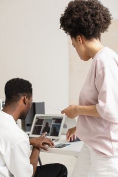 Two colleagues collaborating on a digital project in a modern office setting.