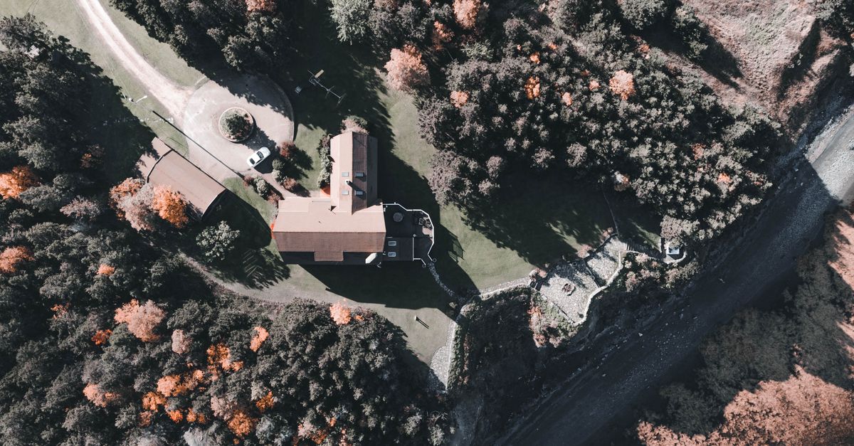 A scenic aerial shot showcasing a countryside estate surrounded by autumn foliage.