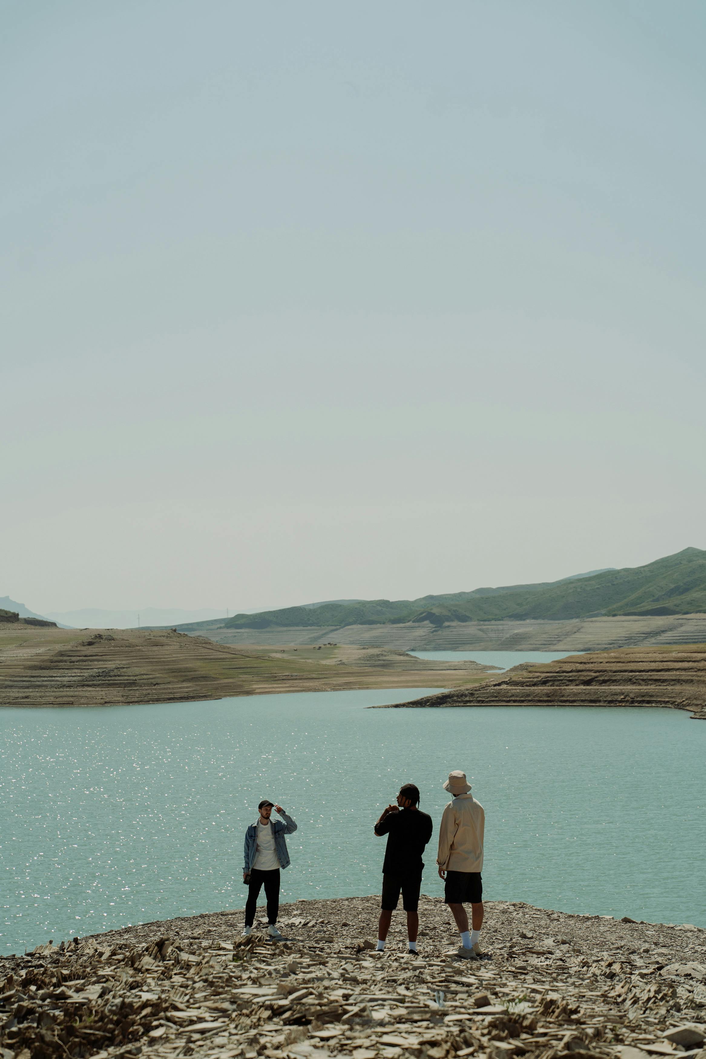 men standing by the lakeside