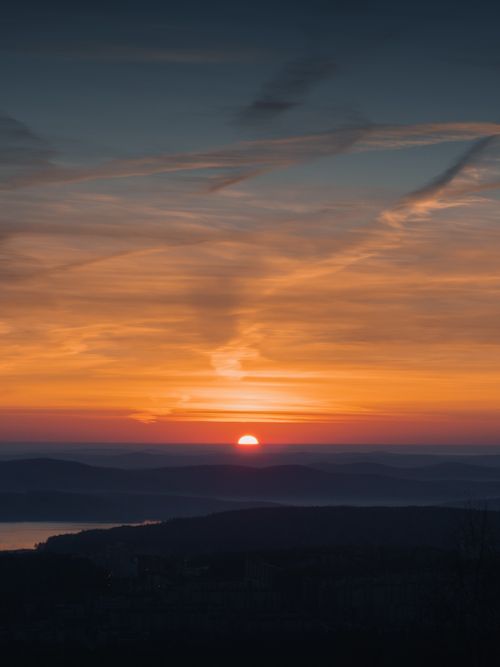 Free Captivating sunset with vibrant skies over distant hills, serene and tranquil. Stock Photo