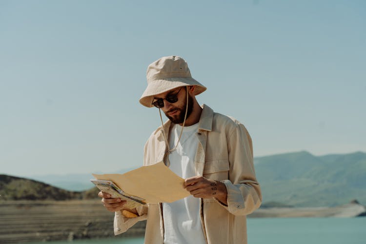 Photo Of A Man With A Bucket Holding A Map