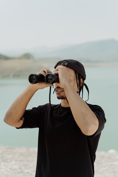 Man in Black Shirt Looking at the Binoculars