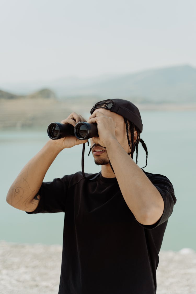 Man In Black Shirt Looking At The Binoculars