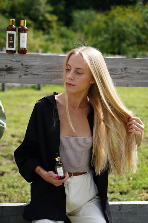 Woman Holding a Brown Bottle