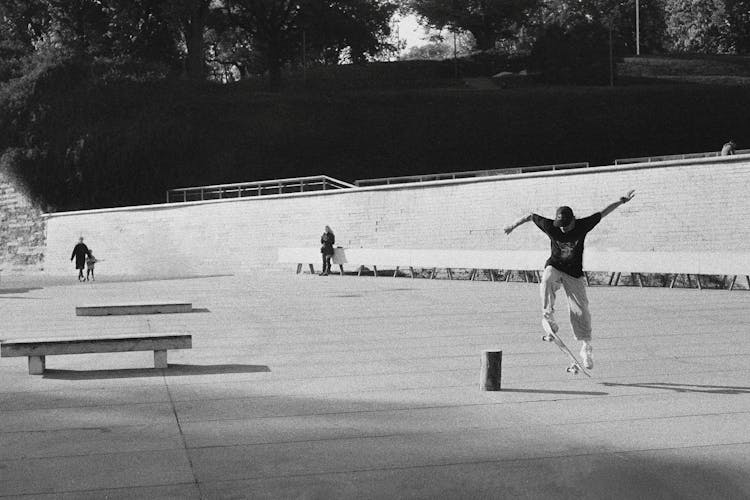 Grayscale Photo Of Person Doing A Skateboard Trick 