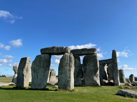 Explore the ancient wonder of Stonehenge under a bright blue sky, perfect for historical and travel themed projects.