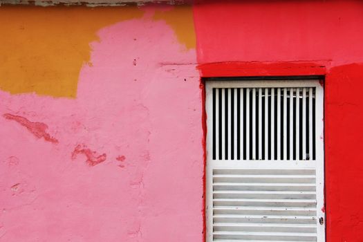 Vibrant painted wall with a white door in Valencia, Venezuela. Perfect for design inspiration.