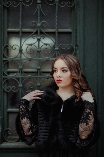 Stunning portrait of a young woman in a luxurious fur coat against a vintage door in Bistrița.