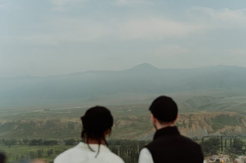 Back View of People Contemplating a Misty Landscape