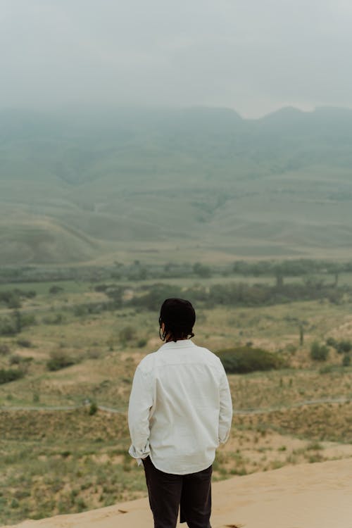 A Person Looking at the View of a Foggy Landscape