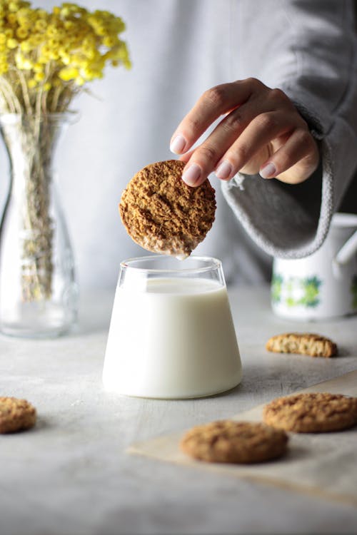Free Person Dipping Cookie in Milk Stock Photo