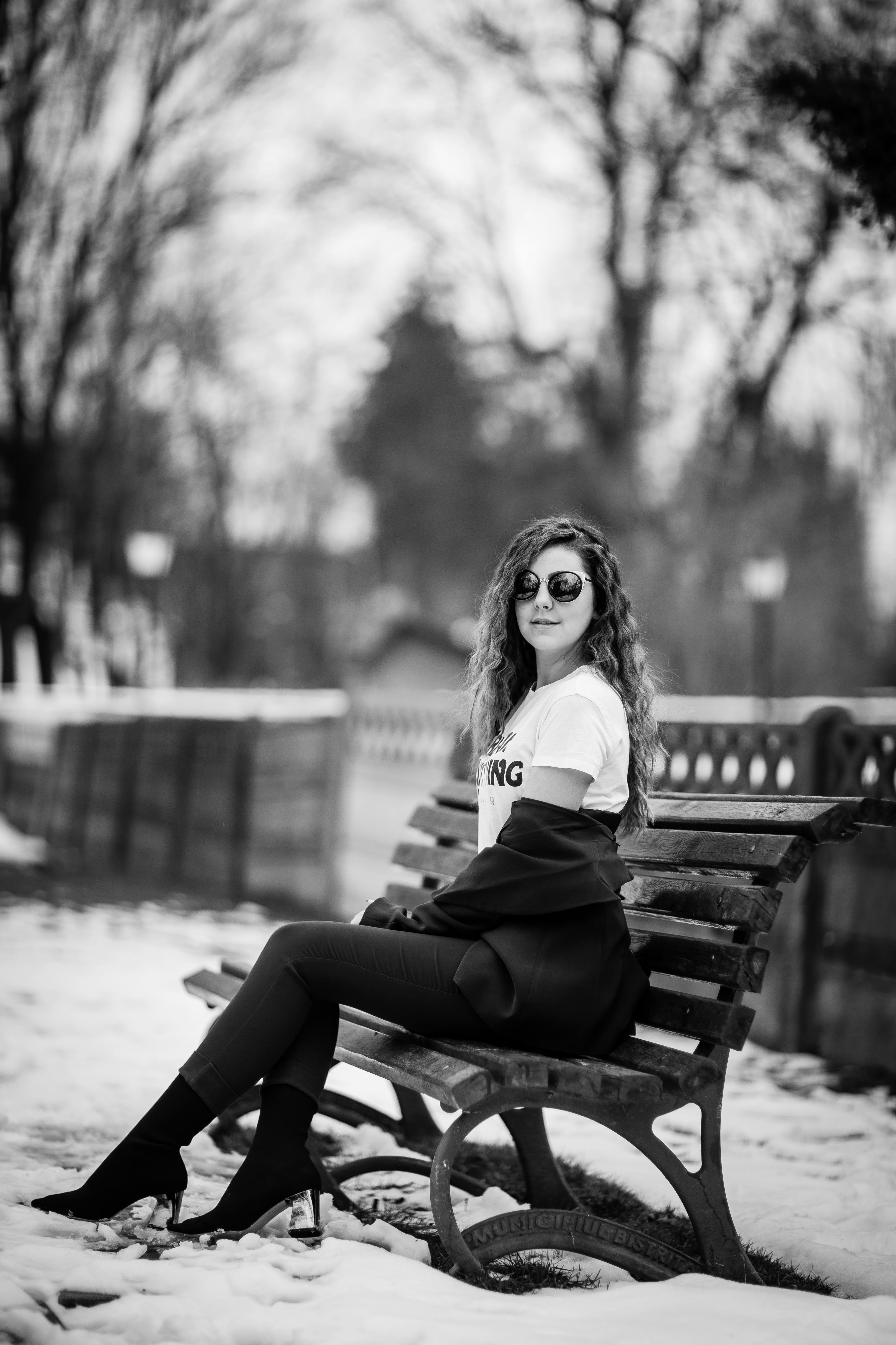 Grayscale Photography of Woman Sitting on Bench