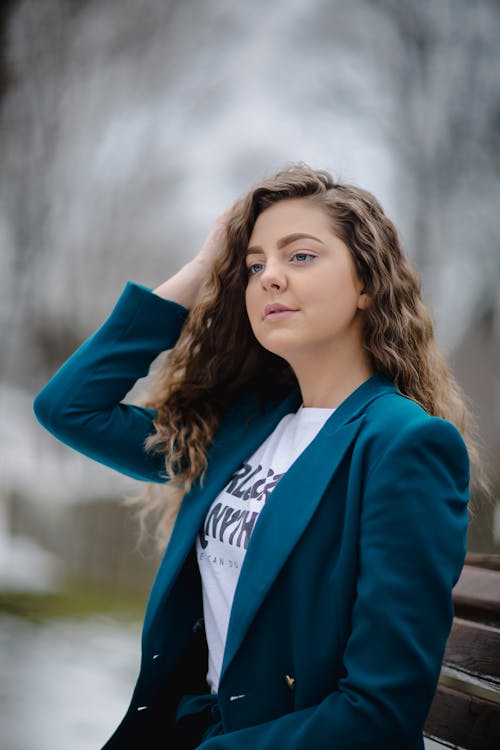 Free Woman Wearing Green Peak Lapel Suit Jacket Sitting on Bench Stock Photo