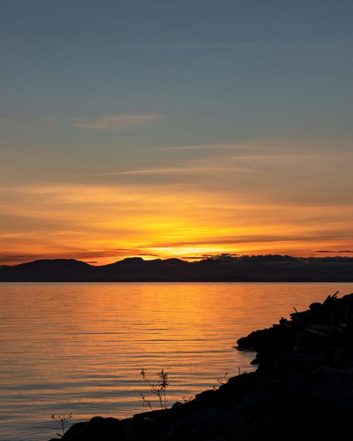 Free A breathtaking sunset over a serene lake in Canada, with vibrant colors reflecting on the water. Stock Photo