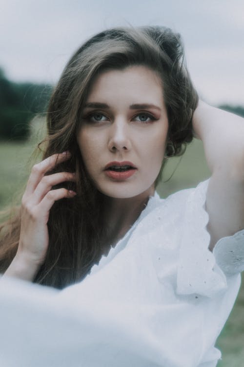 Woman in White Blouse Projecting Beautifully on Camera