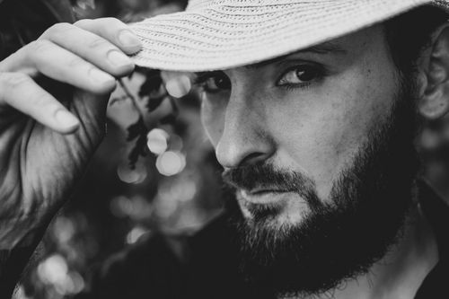 Free Striking close-up portrait of a man with a beard and hat in grayscale tones. Stock Photo