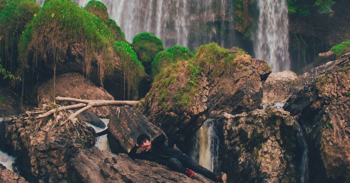 Layed With Rocks Person Laying on Brown Rock Formation · Free Stock Photo