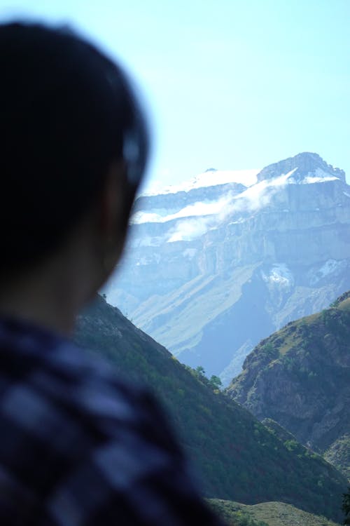 Back View Shot of a Person Looking at the Mountains