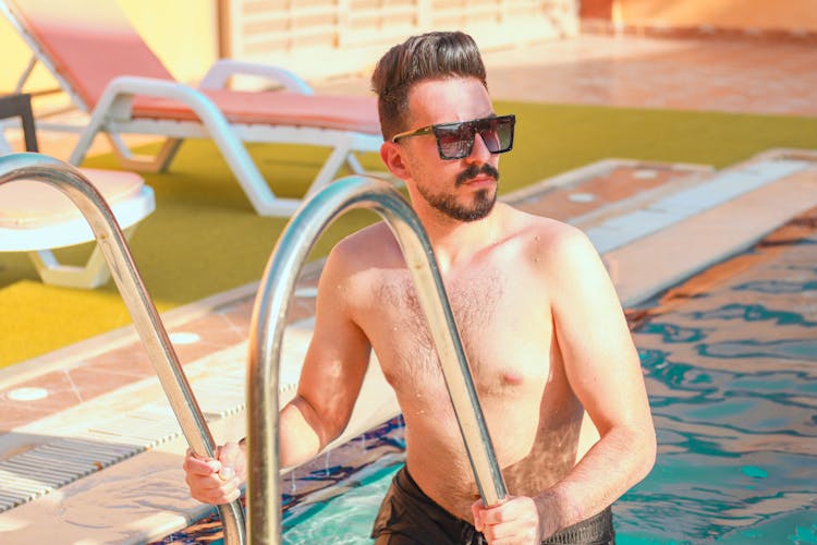 Man In Black Sunglasses Holding The Pool Ladder