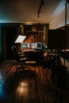 A cozy home workspace with contemporary design featuring a computer, chair, and soft lighting.