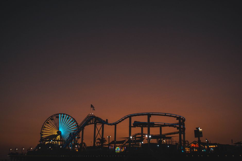 Silhouette of Santa Monica Pier with Ferris wheel glowing at dusk, capturing a vibrant evening scene.
