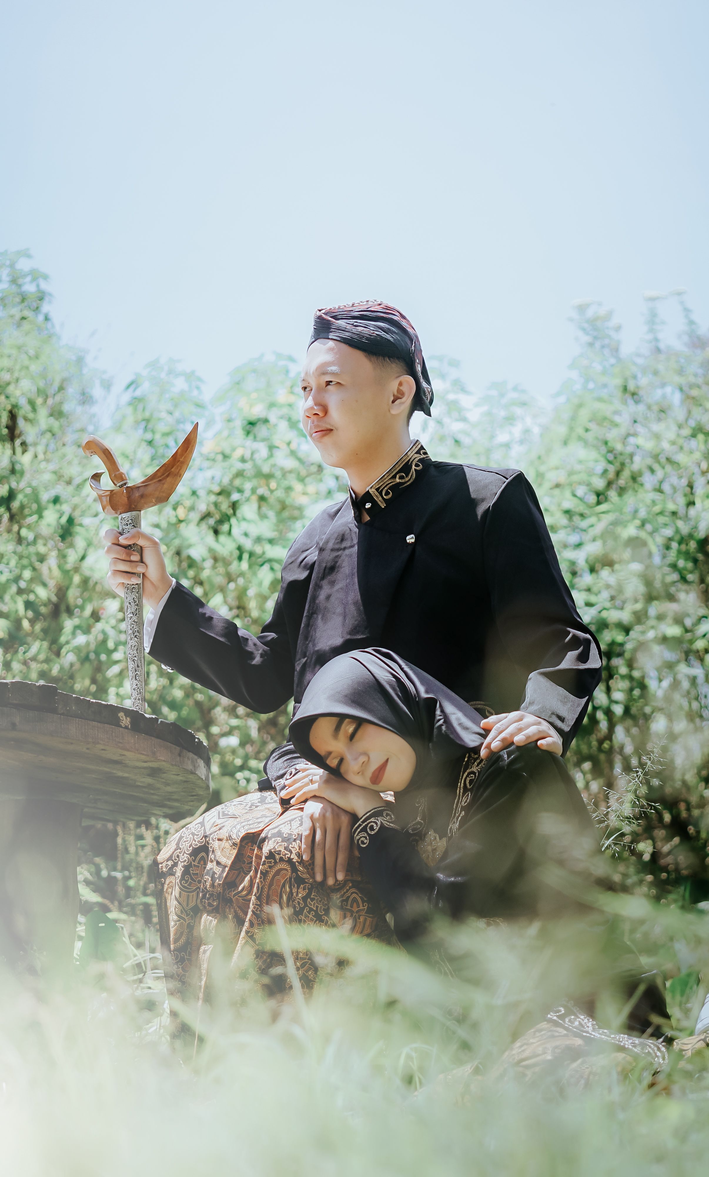 A couple in traditional attire pose outdoors for a prewedding shoot. Vibrant and romantic.