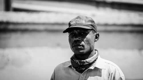 Free Monochrome portrait of an adult man in Tembisa, South Africa, wearing a cap with a blurred background. Stock Photo