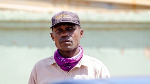 Free Close-up portrait of an adult man with a black cap and purple bandana in Tembisa, South Africa. Stock Photo