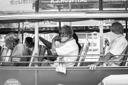 Free Elderly passengers wearing masks on an Indian bus, showcasing pandemic travel norms. Stock Photo