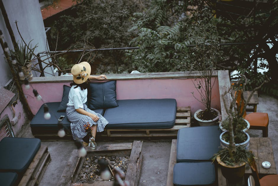 Woman relaxing on an outdoor terrace with greenery in Hanoi, Vietnam.