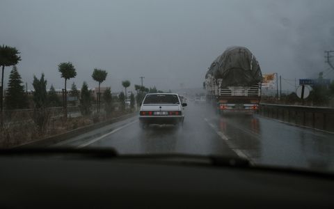Vehicles driving on a wet highway during rainfall