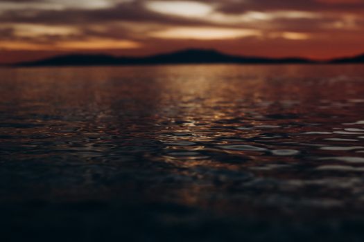 Captivating image of a lake at sunset, showcasing rippling water and a moody sky.