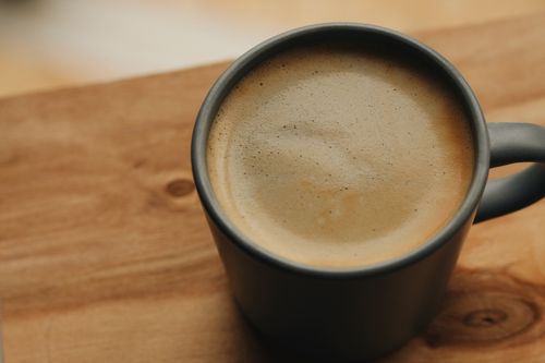 Free Close-up view of a coffee mug on a wooden table, capturing cozy moments. Stock Photo
