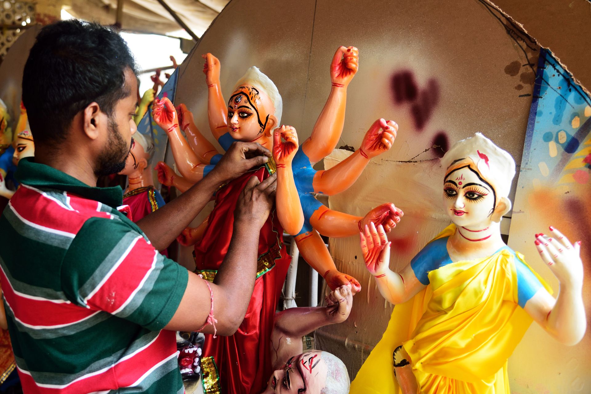 An artisan in New Delhi skillfully crafts statues of Hindu deities, highlighting traditional Indian culture.