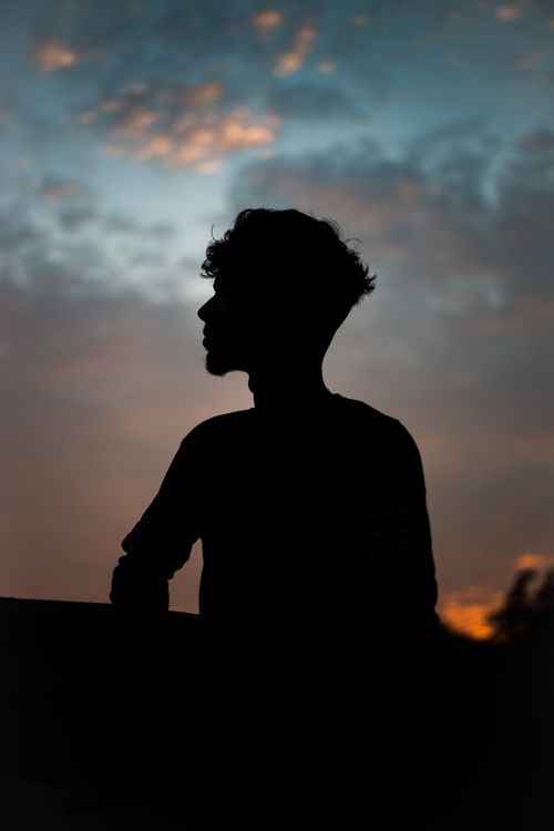 Free A silhouette of a man against a dramatic twilight sky in Goa, India. Stock Photo