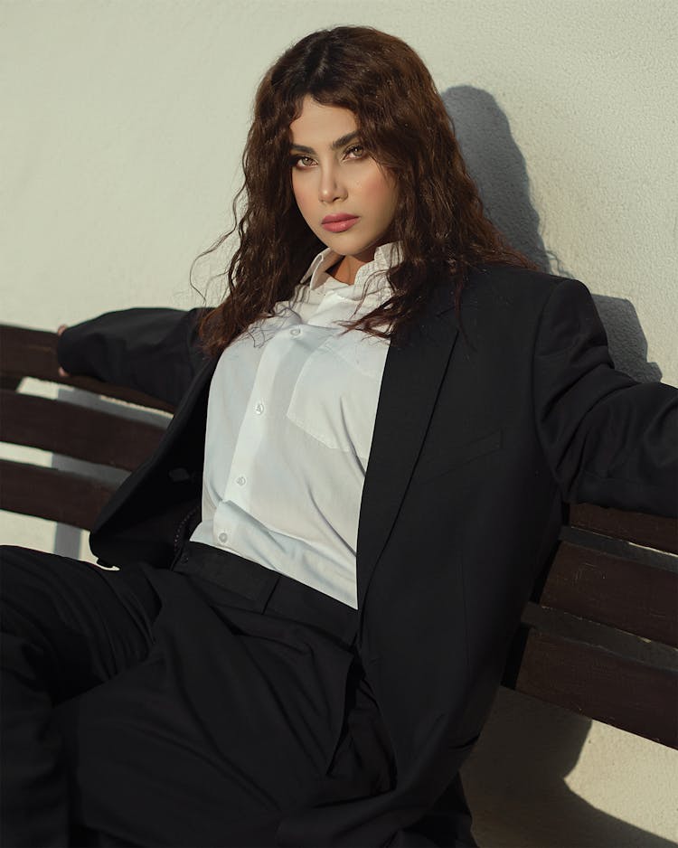 Woman In Black Suit Sitting On Brown Wooden Bench