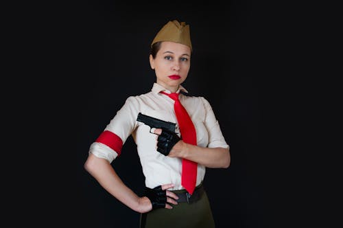 Free Woman Holding a Semi Automatic Pistol near her Chest Stock Photo