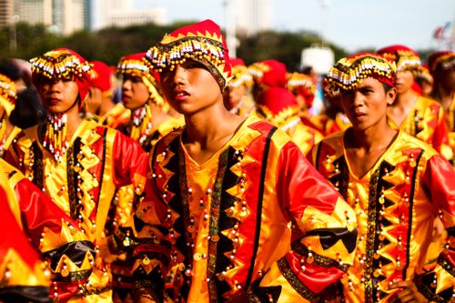 Free Colorful Filipino street festival featuring vibrant traditional costumes in a lively outdoor setting. Stock Photo