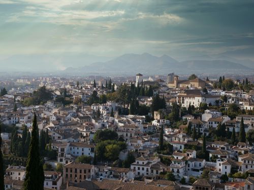 Free Aerial view of Granada cityscape with historic architecture and mountains in the background. Stock Photo