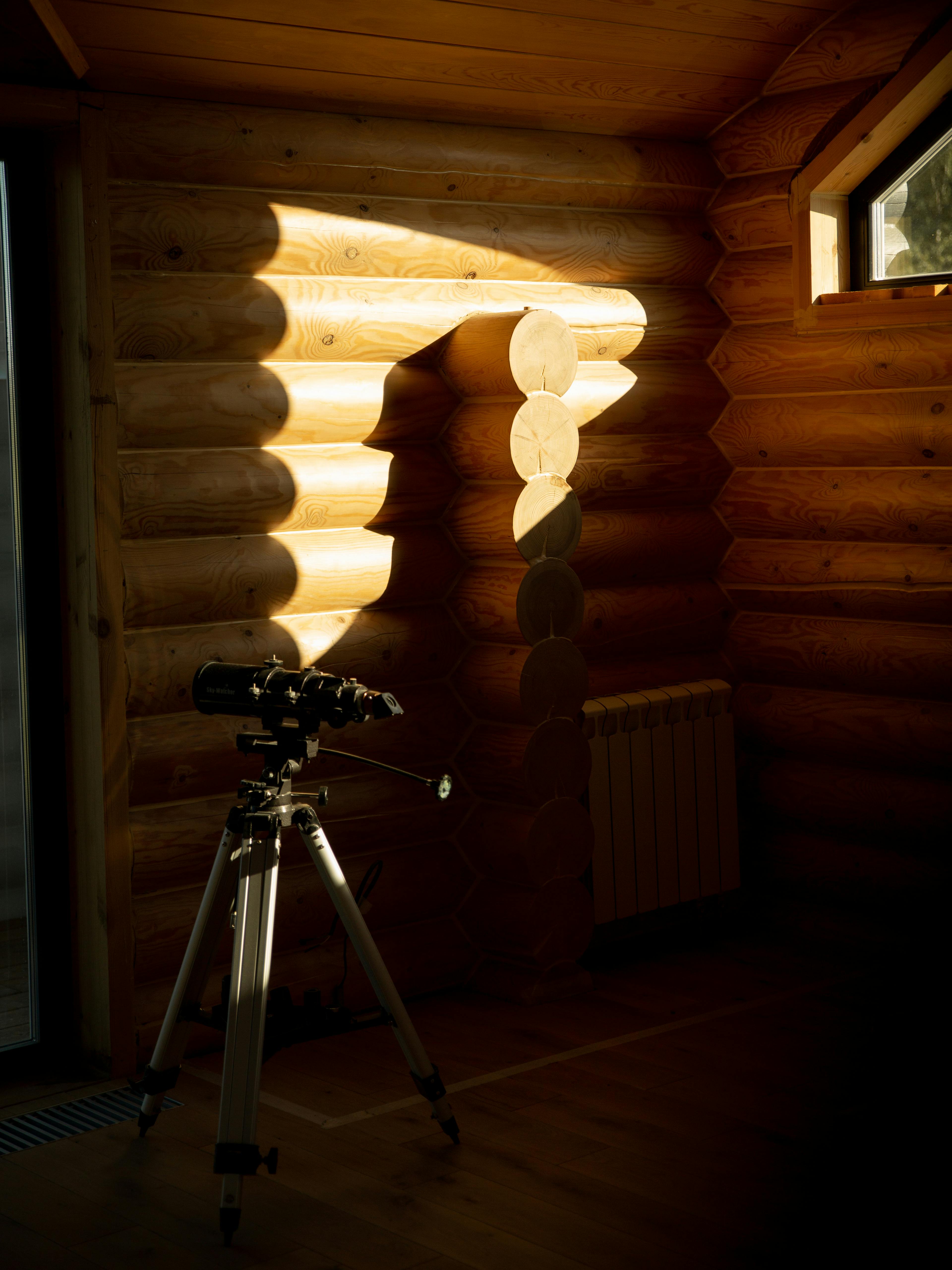 telescope on tripod in log cabin