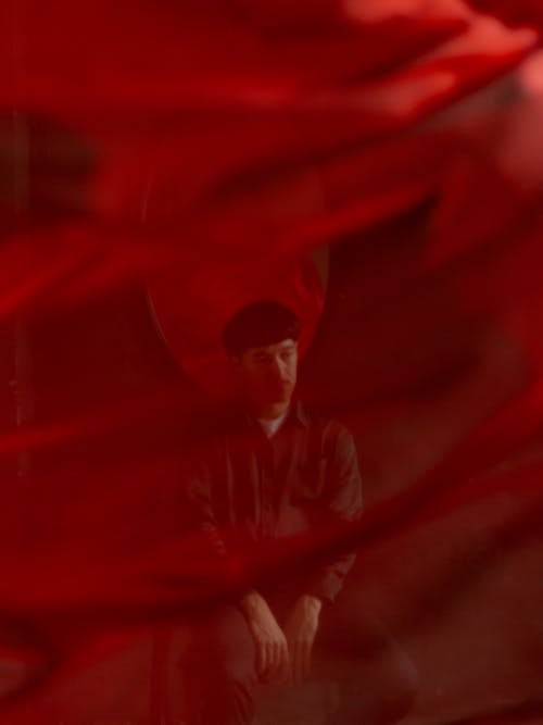 Portrait of Man Behind Red Sheer Fabric