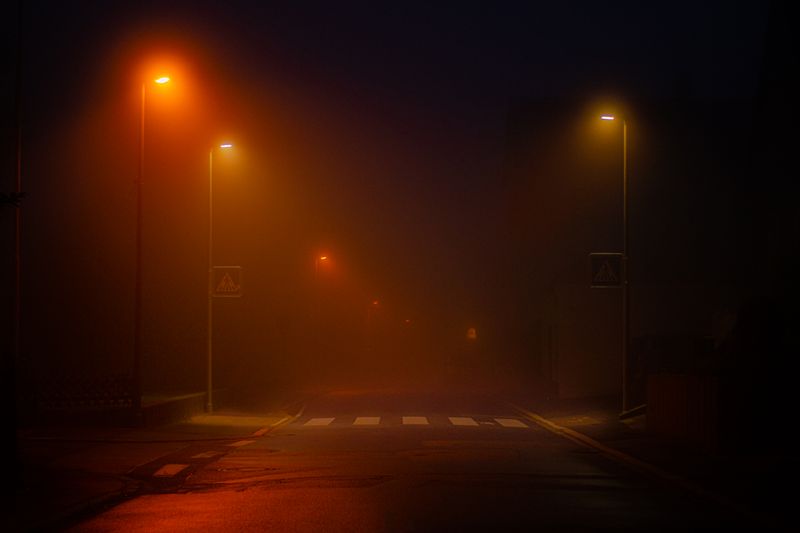Road lined with lit streetlights at night