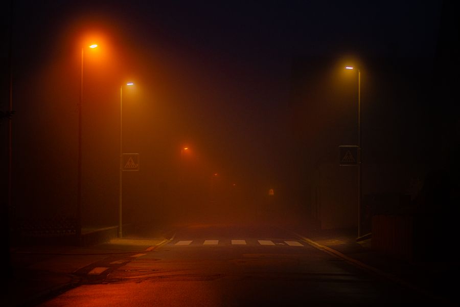 Road lined with lit streetlights at night