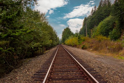 Free A scenic view of railway tracks surrounded by lush forest in Vancouver, Canada. Stock Photo