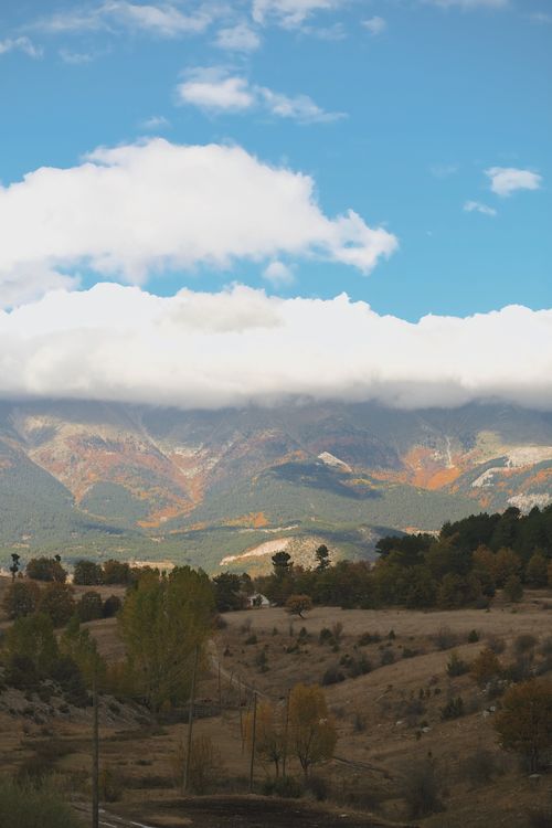 Free Captivating autumn mountain landscape with colorful foliage under a vibrant blue sky. Stock Photo