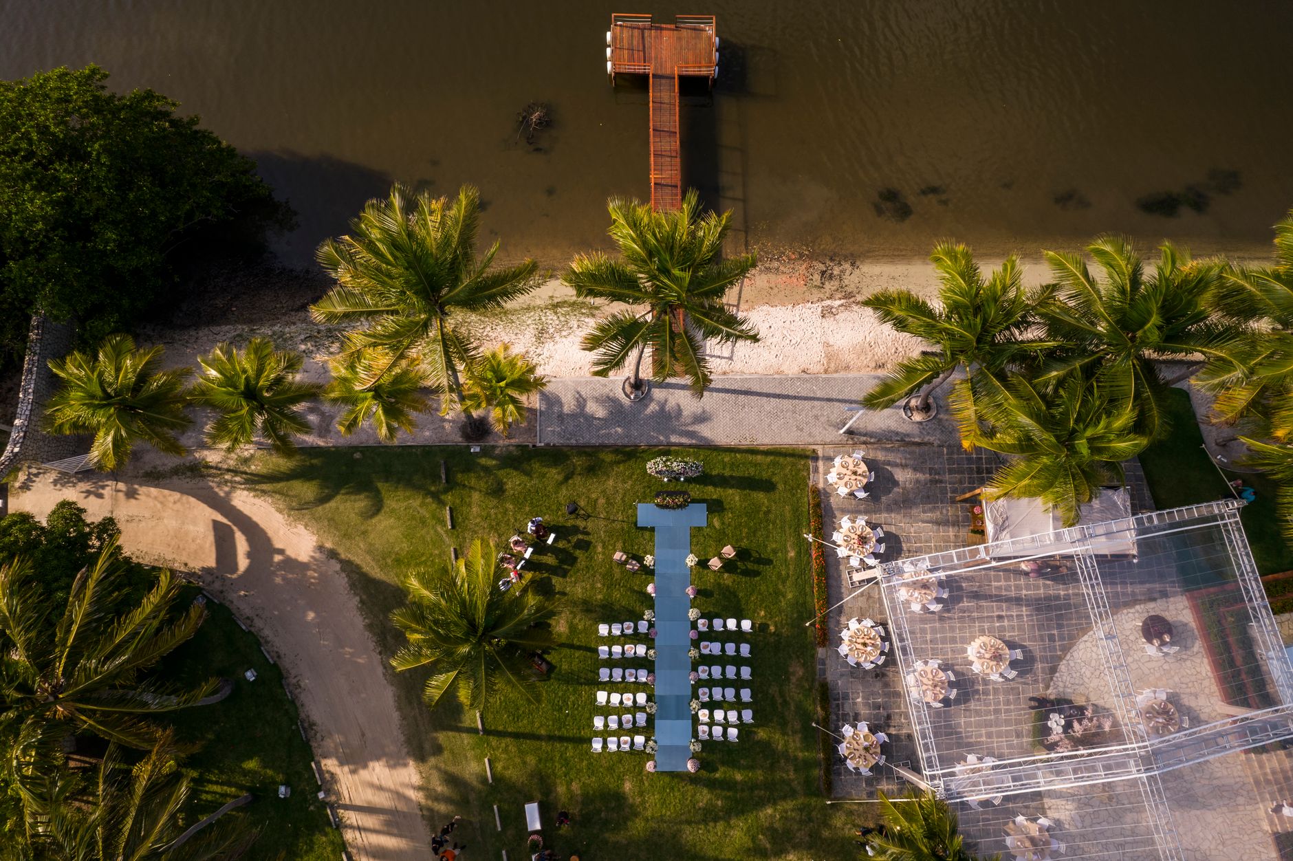 Aerial photograph of a tropical wedding venue with palm trees and waterfront in Santa Rita, Brazil.