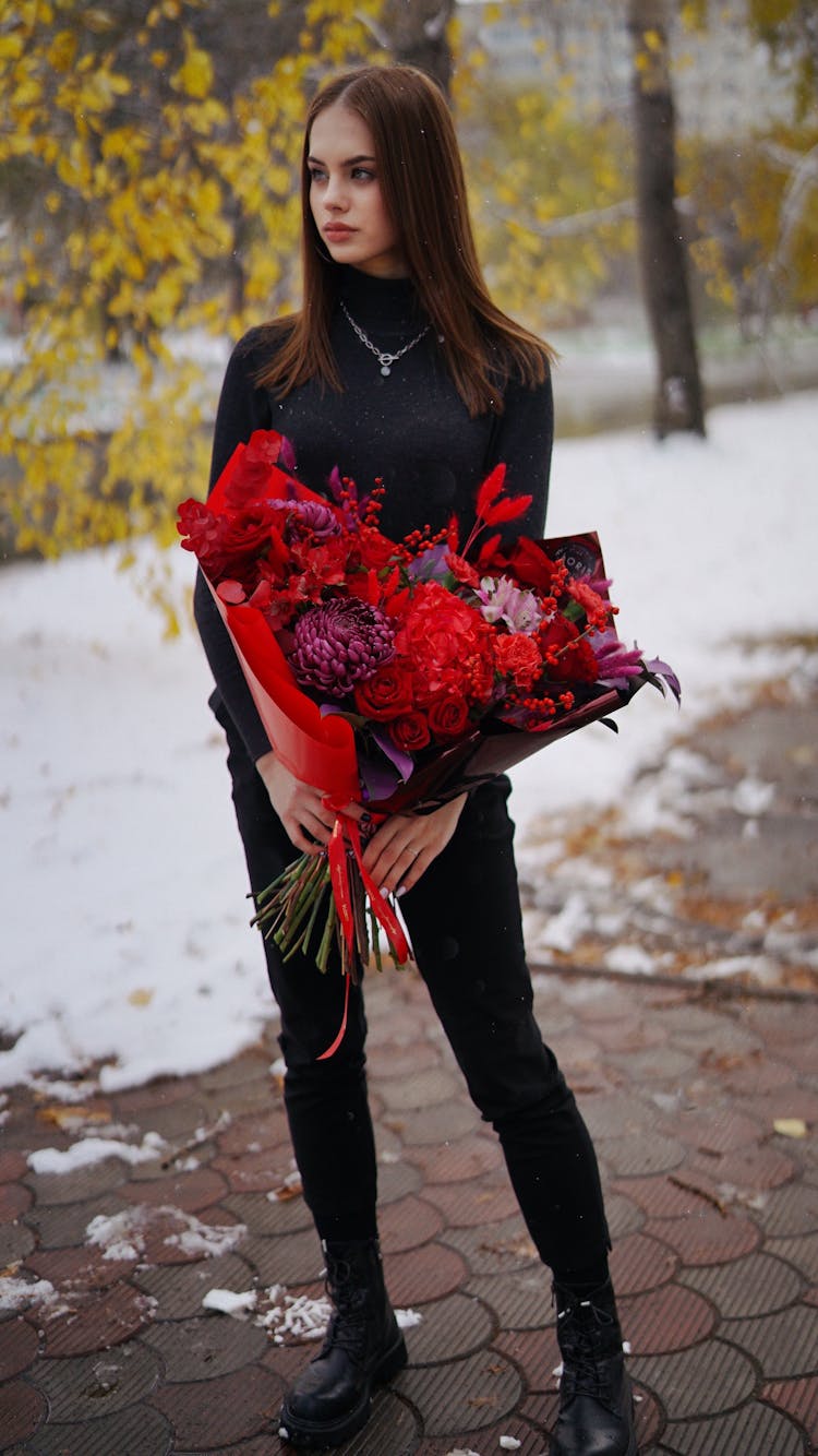 Woman Dressed In Black Holding Large Red Flower Bouquet