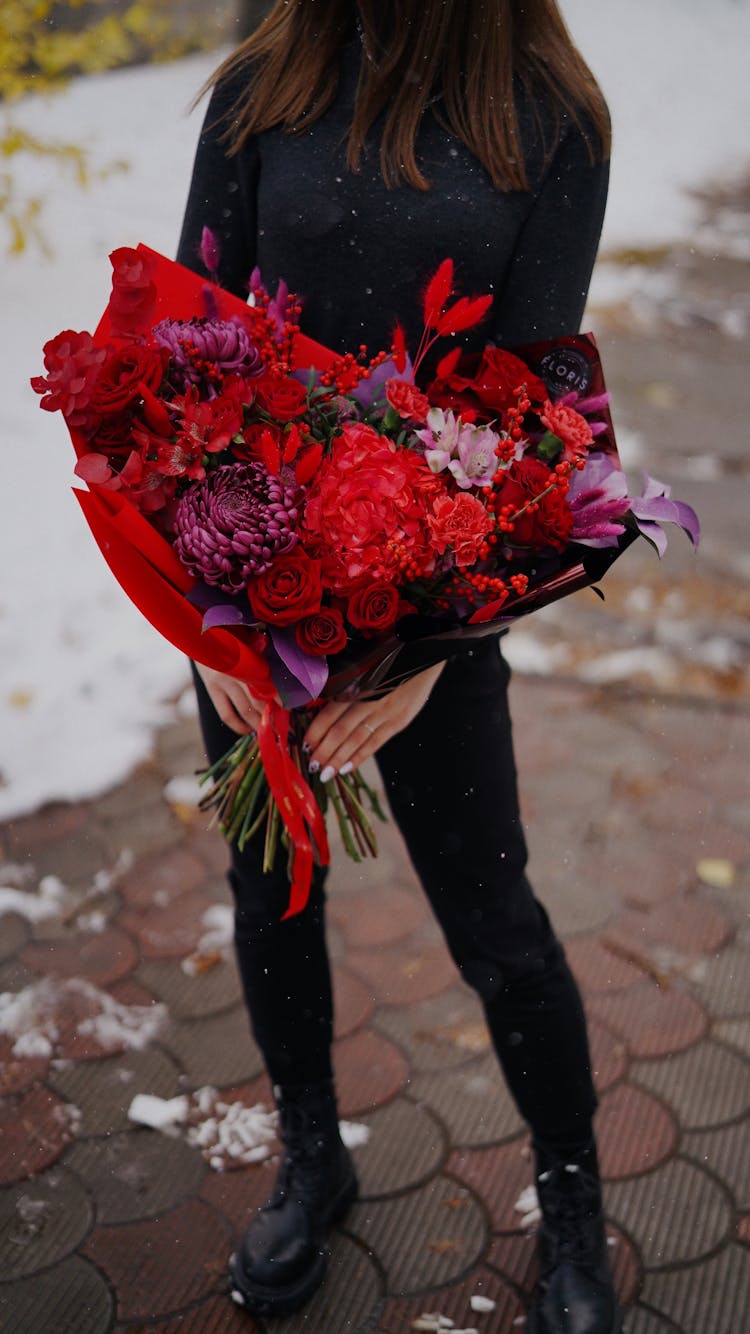 Woman Dressed In Black Holding Large Red Flower Bouquet